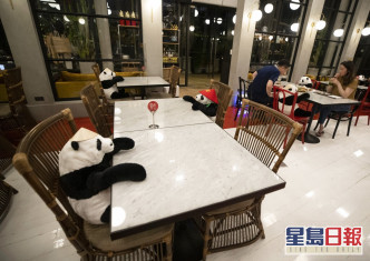 泰國曼谷有餐廳利用熊貓公仔陪伴客人用餐。AP圖片