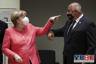 德國總理默克爾（左）看到保加利亞總理鮑里斯索夫口罩滑下來時，假裝驚嚇地指著對方鼻頭。 AP