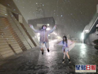 滂沱大雨下，有市民身穿雨衣在海邊感受風力。