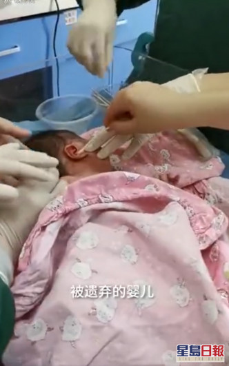 医护为女婴清理耳内的蛆虫。网图