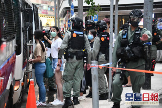 警方将被捕人士扣押上旅游巴。