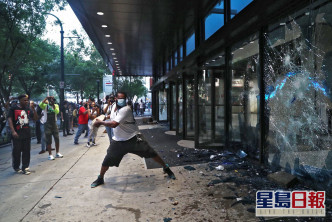 示威者擊碎大樓玻璃。 AP