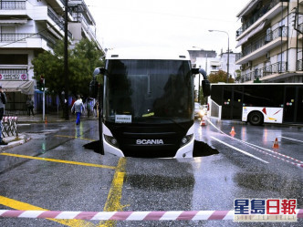 雅典有马路路陷，导致一辆巴士被困。AP图
