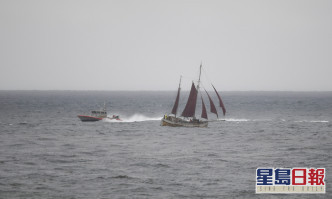 一艘美國海岸警衛隊的小船正進行搜尋工作從經過的帆船附近駛過。AP圖片
