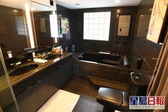 浴室设计沉实奢华，以深啡色砖材铺设。