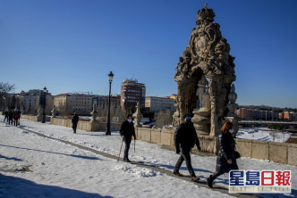 人們在西班牙馬德里托萊多橋的雪地上行走。AP圖片