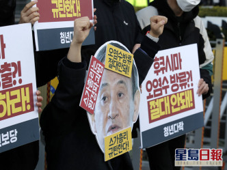 有示威者帶上日本首相的面具。AP圖片