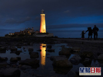 在英格兰的惠特利湾，圣玛丽灯塔亮灯纪念抗疫一周年。AP图片