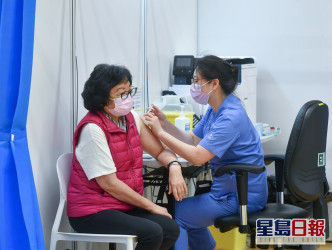 前民政事務局常任秘書長李麗娟（左）接種疫苗。