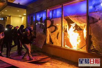 示威者破壞商店。 AP