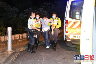 杨明烂醉如泥，由警员扶上救护车。