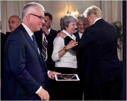 特朗普搭著英国首相文翠珊的膊头，文翠珊咧嘴而笑。AP