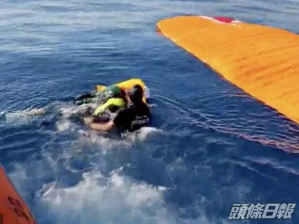 海岸警衛隊人員將運動員從水中救出並運送往醫院。路透社圖片