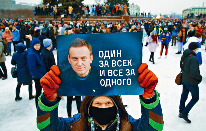 ■示威者在聖彼得堡，舉起印有納瓦爾尼肖像的海報。