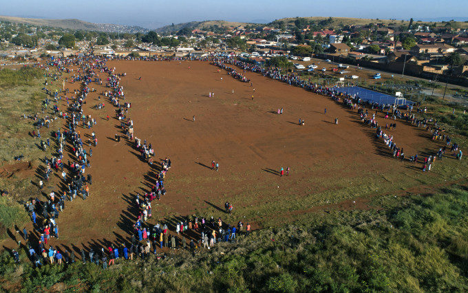 南非比勒陀利亞大批民眾在疫情下排隊等候領取食物援助。 AP圖
