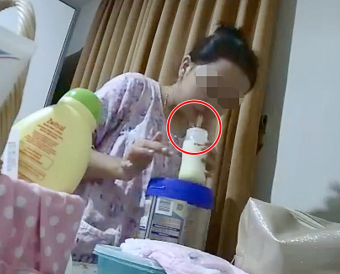 外佣对准奶樽吐出一大啖痰或口水的液体。影片截图
