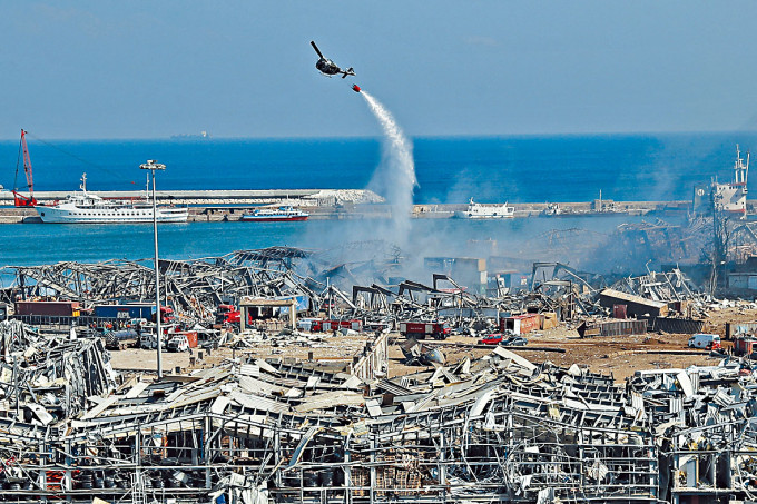 ■軍方直升機在空中灑水，撲滅大爆炸引發的火災。