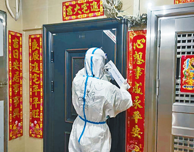 廣州防疫人員為發生疫情的住宅貼封條。