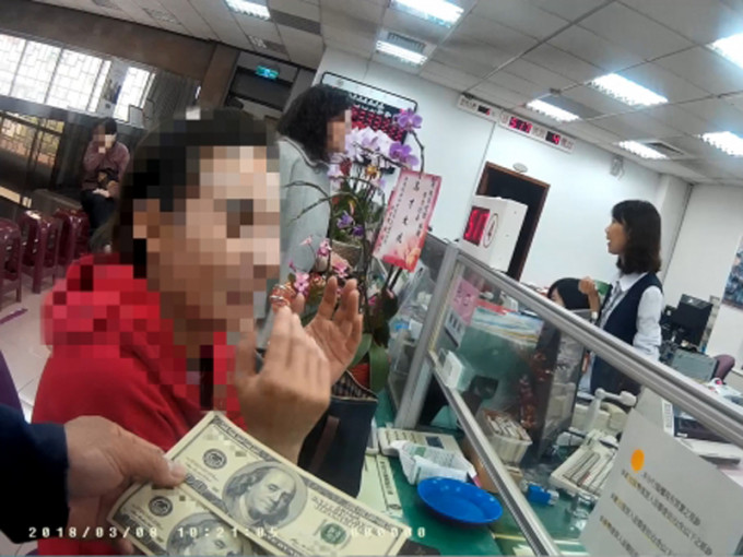 女侍应陈女士（左）5年前收了客人给的2张百元美钞，日前拿到银行兑换才知是伪钞，被警方带回派出所。（网图）