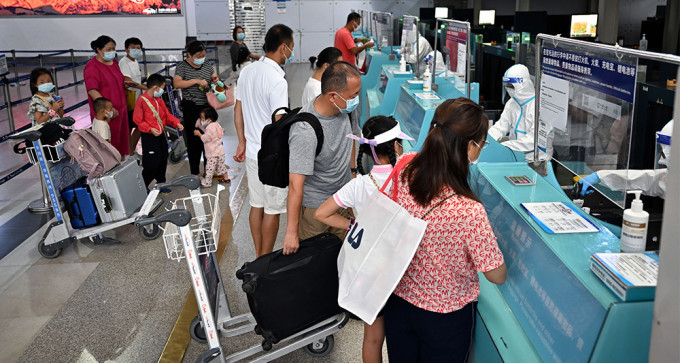 首批滞留海南三亚游客返程，昨日在机场办理登机手续，前往西安。（新华社）