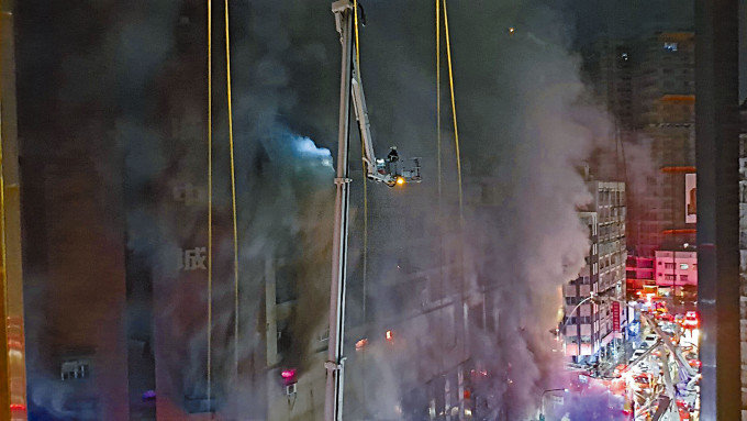 高雄市「城中城大楼」遭烈火及浓烟包围，消防冒险用云梯抢救受困住户。