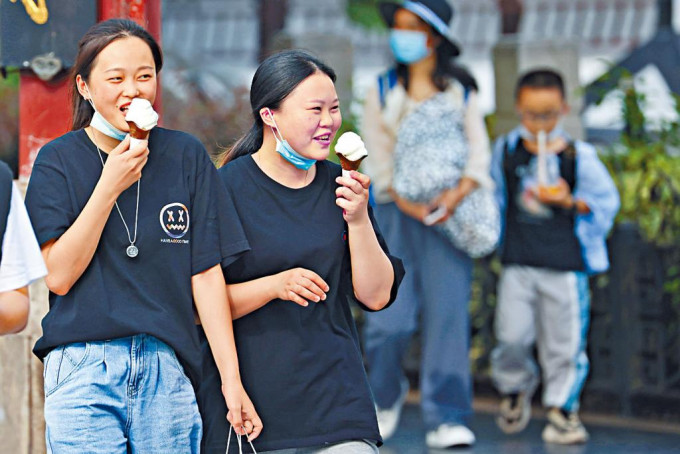 炎熱天氣下，江蘇南京市民在街頭吃雪糕。