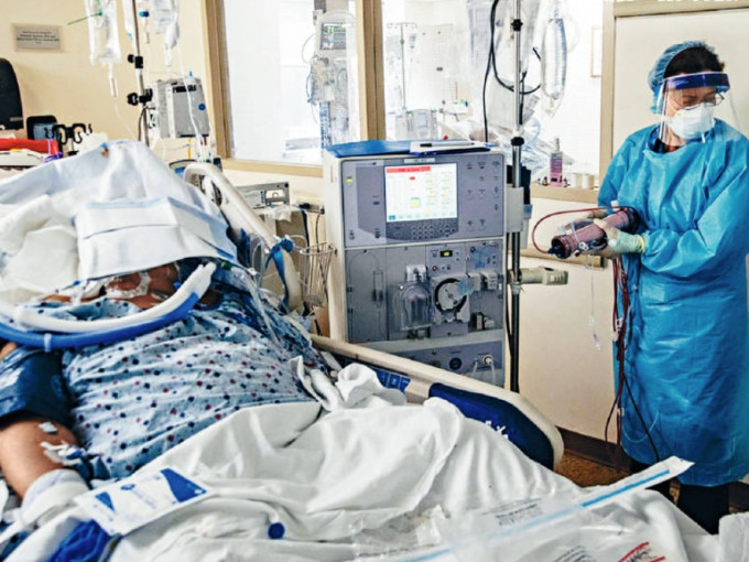 纽约布鲁克林一所医院的护士，上周四在深切治疗部照料一名洗肾病人。网图