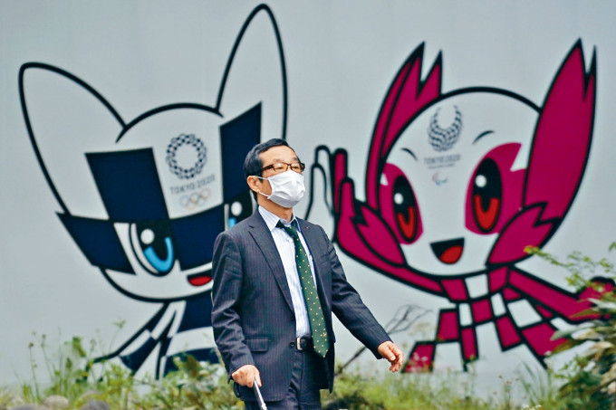 戴口罩男子在東京一幅奧運吉祥物壁畫前走過。