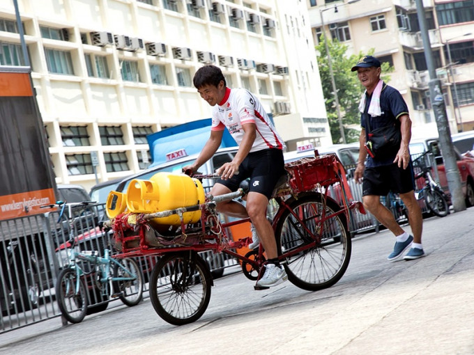 阿寶試踩雄哥的單車，單是載兩罐石油氣都要時間掌握平衡。