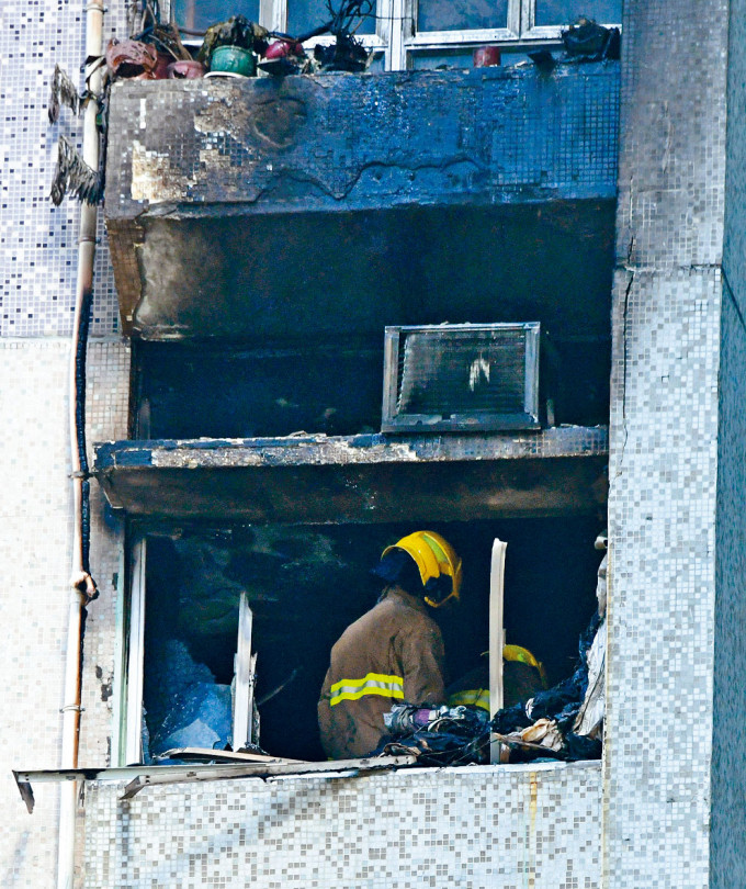■五樓單位嚴重焚毀，消防員展開調查。