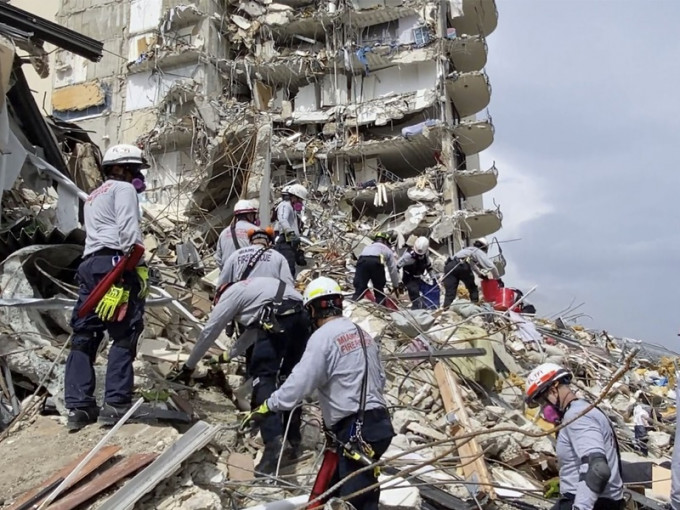 消防員爭分奪秒在瓦礫中尋找倖存者。AP