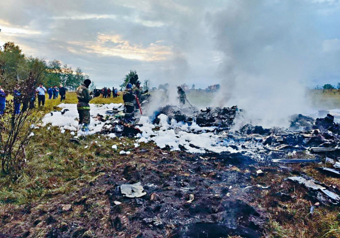 俄消防員周三在墜機現場滅火。