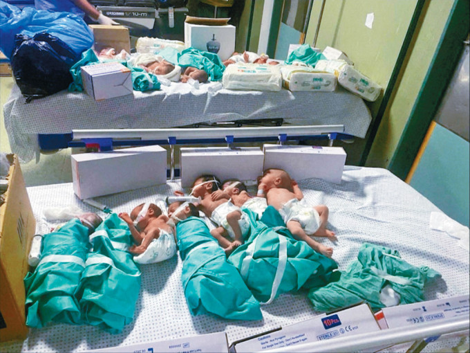 加沙城希法医院断电，新生早产婴从保温箱中被抱出放在床上。