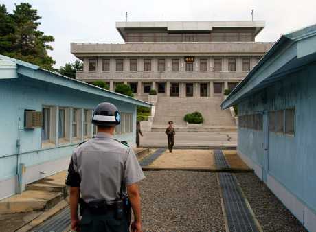 韩国宪兵（前）和朝鲜人民军军官分别在军事分界线两侧执勤。新华社
