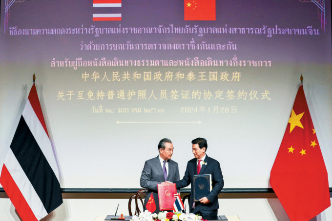 外長王毅（左）和泰國副總理兼外長班比（右）正式簽署永久互免簽證協議。