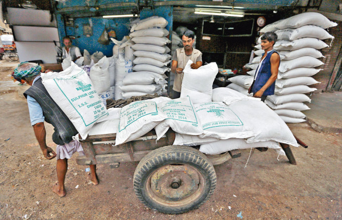 印度西部批发市场的工人在搬运砂糖。