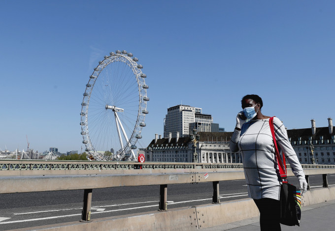 英國政府稱疫情已見頂，當地有專家籲社交距離規定今年內維持。 AP圖