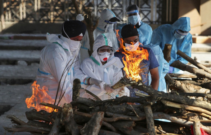 印度工作人員火化新冠肺炎死者遺體。AP圖片
