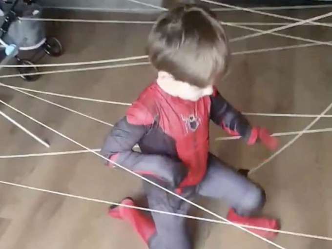 英國一名母親在隔離期在家動手用繩子在屋內「織出蜘蛛網」讓孩子玩耍。(網圖)