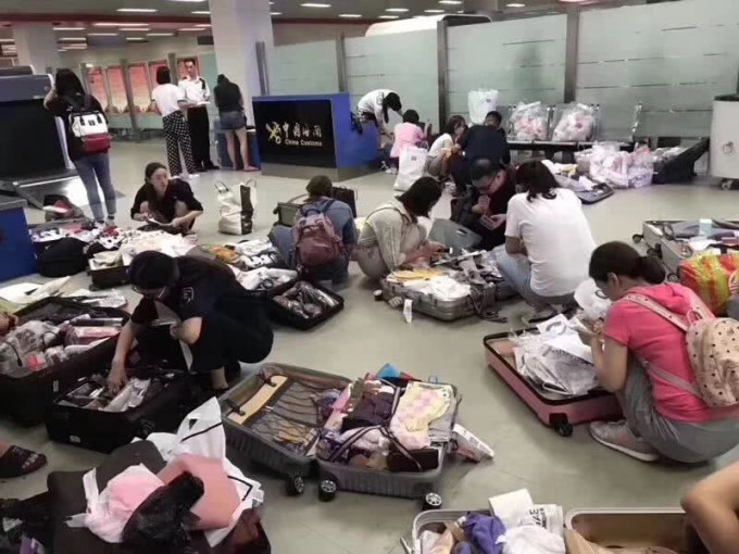 有网民指上海浦东机场「一班航班查了100多个代购，排队等待交税」。网图