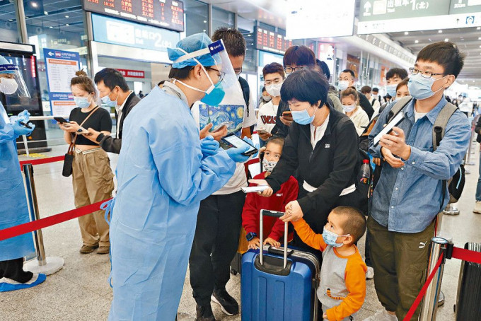 國慶期間旅客猛增，上海防疫人員查驗旅客的健康碼。