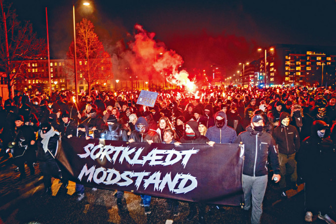 ■示威者拉起「抵抗」字樣的橫額，在哥本哈根抗議疫苗護照。