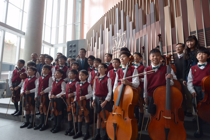 学童获邀在综合大楼内表演弦乐。