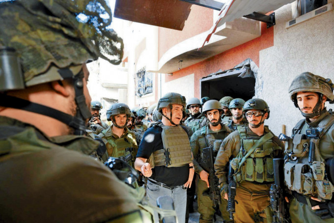 以色列总理内塔尼亚胡（中）周日到加沙地带视察，与官兵交谈。