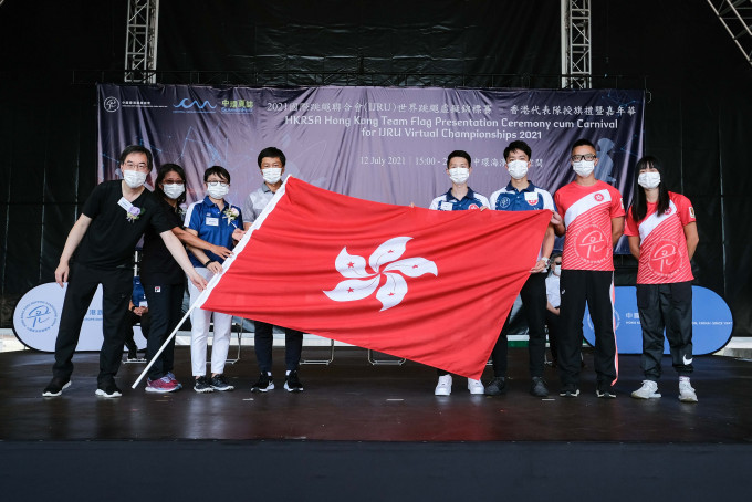 民政事務局體育專員楊德強將香港區旗交予香港隊總教練及運動員代表。 公關圖片