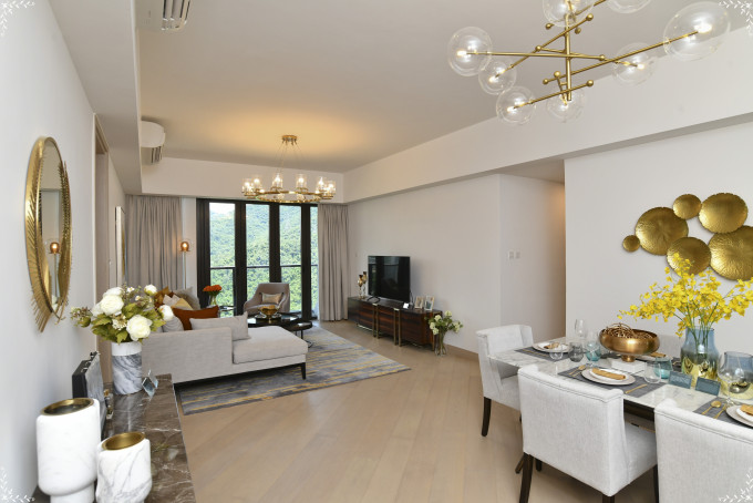 客廳擺放偌大曲尺形駝色沙發，打造舒適放鬆身心的空間。