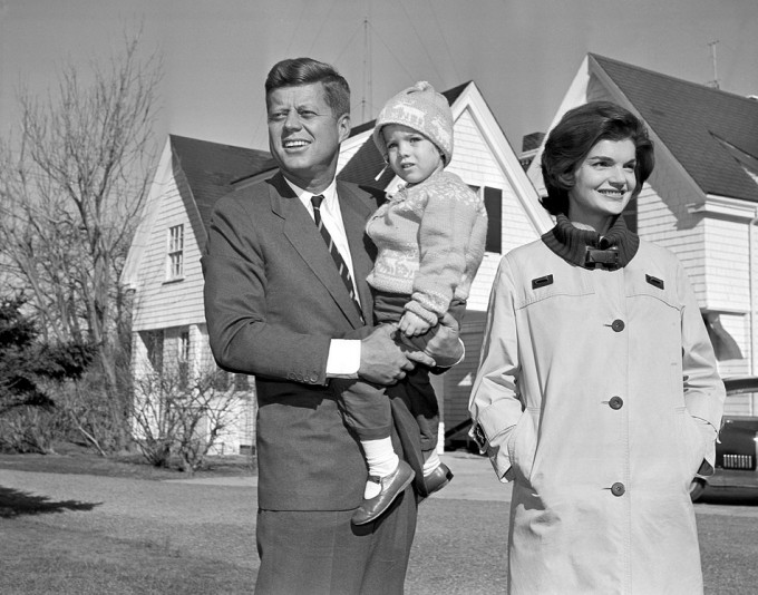 1960年总统甘乃迪手抱女儿与积琪莲在家外拍照。AP图片
