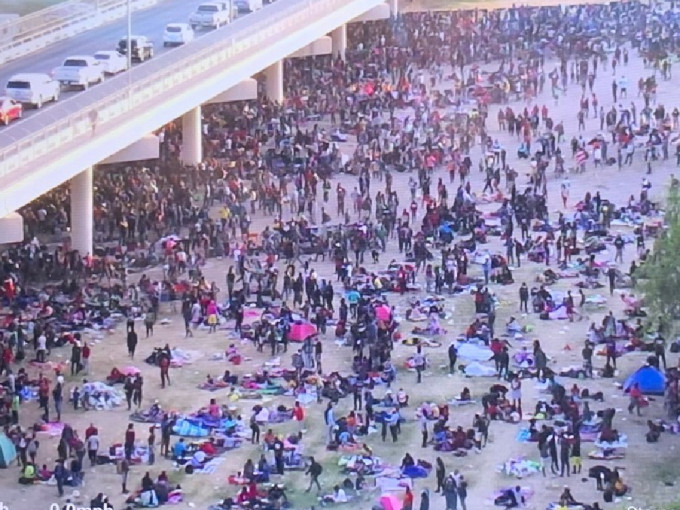 大量非法移民聚集在美墨边境的大桥下，希望进入美国。（片段截图）