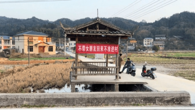 「不帶女朋友回來不准進村」橫幅惹村民反感。