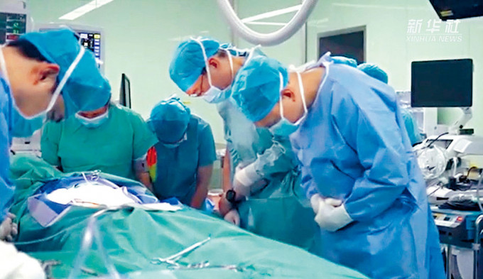 內地醫生在展開女嬰摘心手術前，鞠躬向遺體致敬。